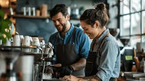 Team of baristas and coffee experts working in a cafe, smiling while preparing drinks and talking to customers